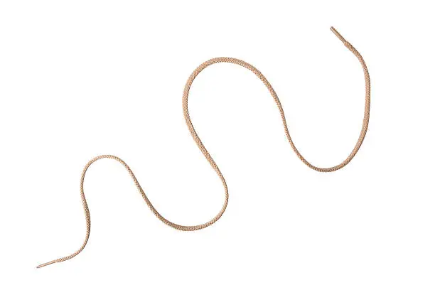 A tan colored shoelace, curved, isolated on white