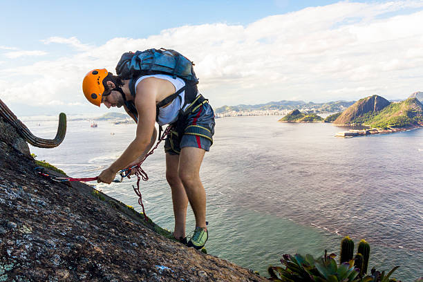 Young Brazilian man climbing the Sugarloaf mountain.