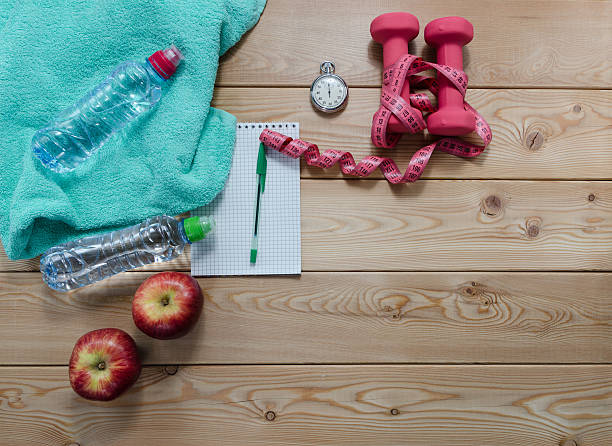 istock notebook  stopwatch apples towel dumbbells and measure tape 614127174
