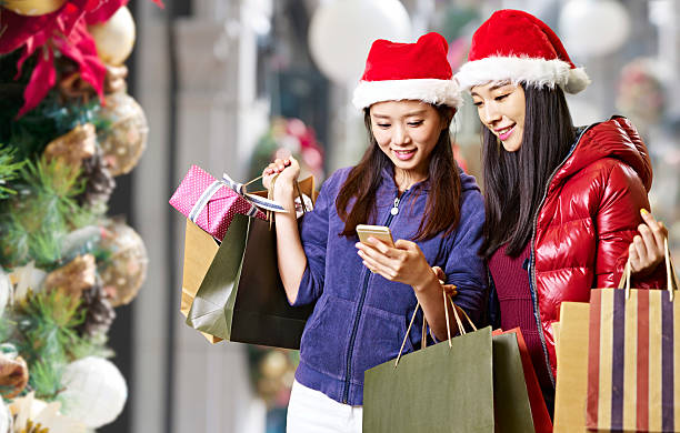 istock young asian women using cellphone during christmas shopping 614128272