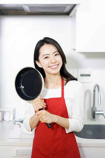istock Woman holding frying pan 614128356