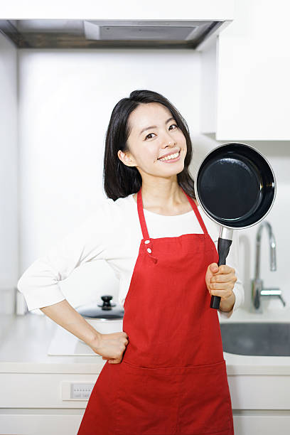istock Woman holding frying pan 614128446