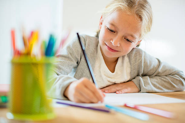 Doing homework Schoolgirl. Shallow DOF. Developed from RAW; retouched with special care and attention; Small amount of grain added for best final impression. 16 bit Adobe RGB color profile. creative writing class stock pictures, royalty-free photos & images