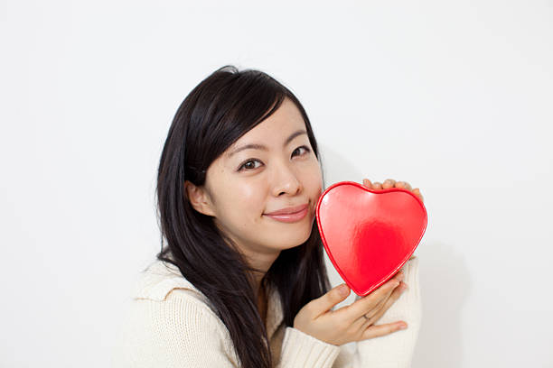 istock Woman holding heart-shaped box 614130730