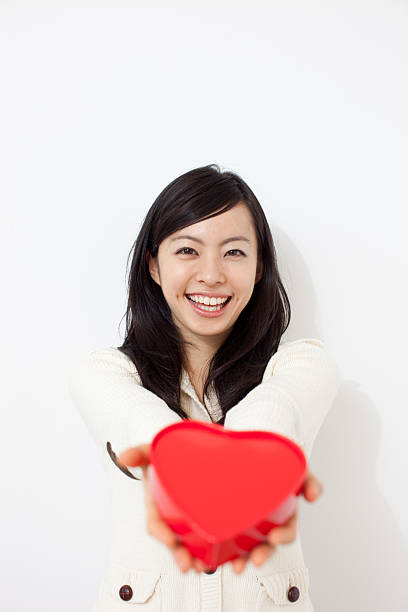 istock Woman holding heart-shaped box 614130752