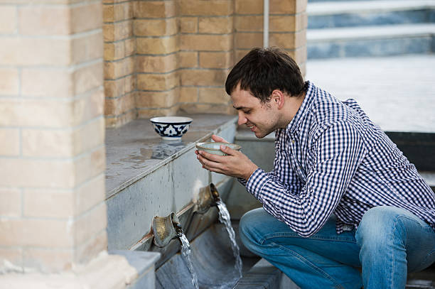 istock man drink fresh water from spring in the village 614131302