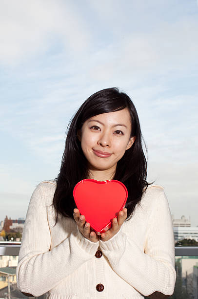 istock Woman holding heart-shaped box 614132256