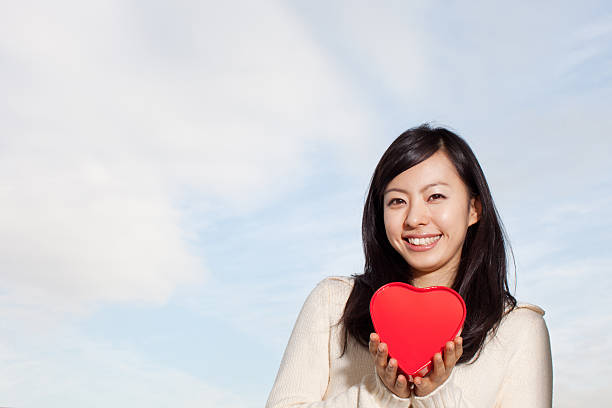 istock Woman holding heart-shaped box 614132312