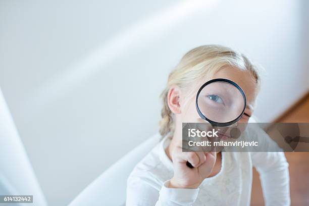 Little Girl Looking Through A Magnifying Glass Stock Photo - Download Image Now - Child, Magnifying Glass, Detective