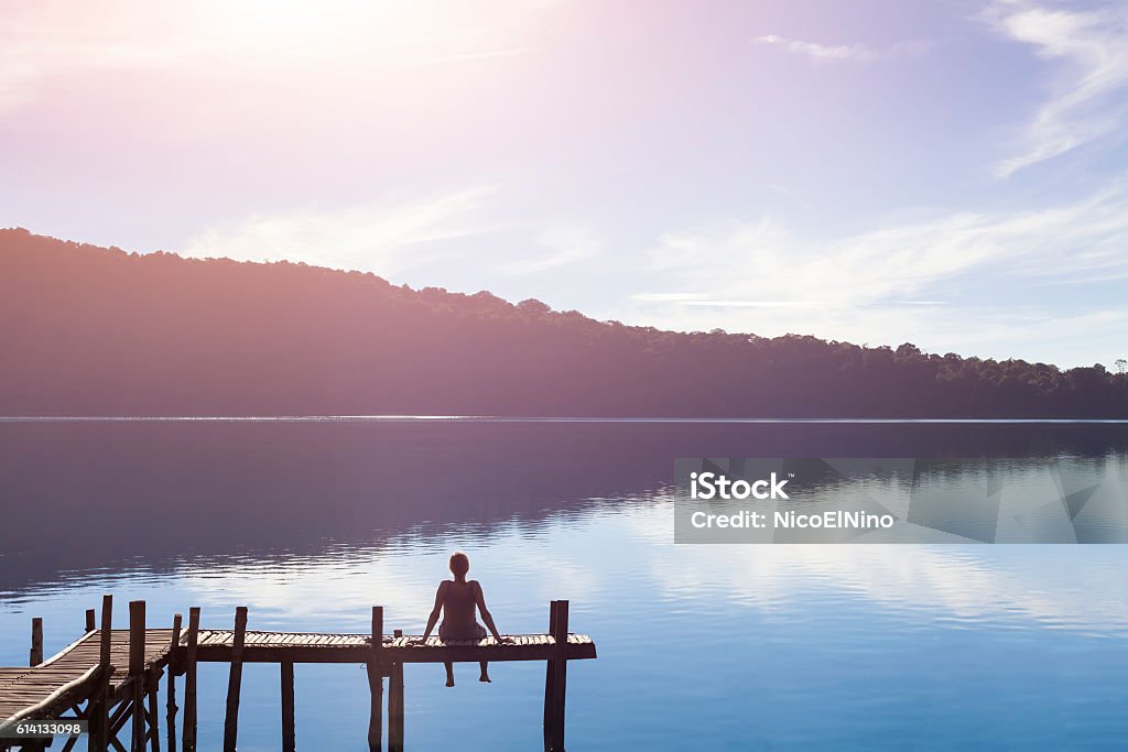 Glückliche Frau sitzt auf einem Pier immer von der Natur inspiriert - Lizenzfrei Betrachtung Stock-Foto