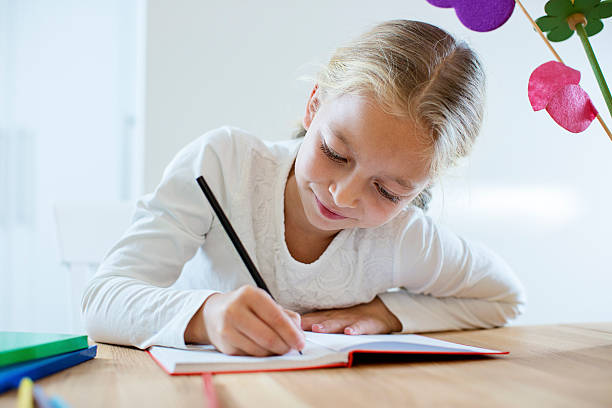 istock Little girl writing 614133190