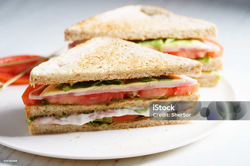 ham sandwich Sandwich of whole wheat bread with ham, cheese and fresh tomato, triangle cut, three layers sandwich bread Sandwich Stock Photo