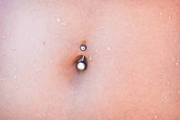 istock Piercing on female stomach, close up 614135226