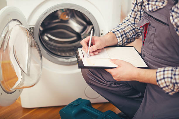 repairman está reparando una lavadora en el fondo blanco - small appliance fotografías e imágenes de stock