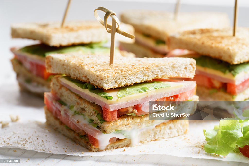 ham sandwich Sandwich of whole wheat bread with ham, cheese and fresh tomato, triangle cut, three layers sandwich bread Sandwich Stock Photo