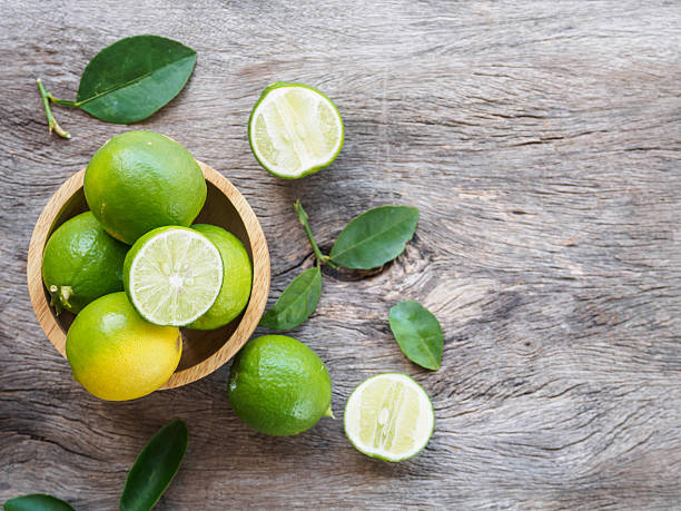 Top view of green lemon group and slice in bowl