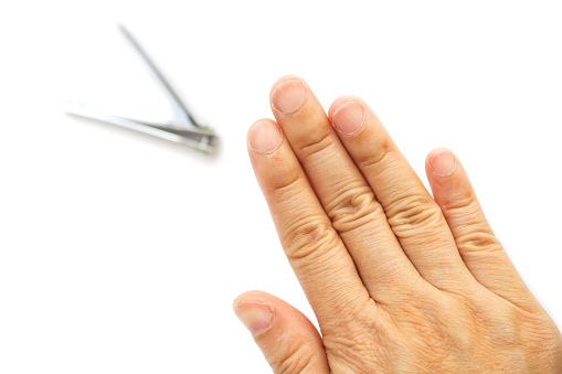 Clean and short finger's nails. Woman cutting nails on white background. Healthcare, cleaning lifestyle.