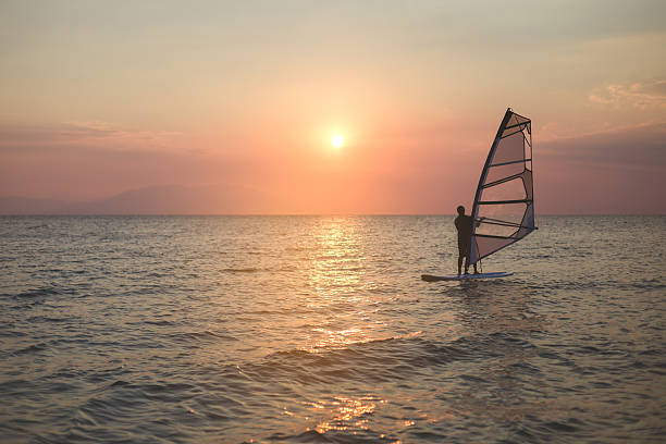 istock man windsurfing on a beautiful sunset 614141738