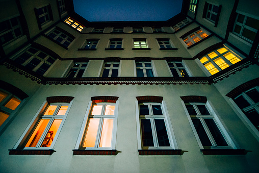 A residential building at night in Berlin, Germany, with lights coming from some of the windows.