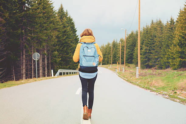 istock Young woman on a countryside road. 614146154