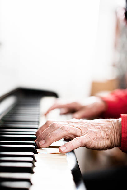 istock Wrinkled arthritic hands playing the piano 614148488