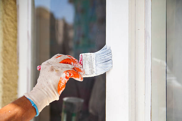 istock Man painting frame of the window 614149280