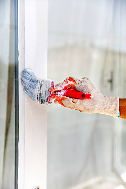istock Man painting frame of the window 614149676