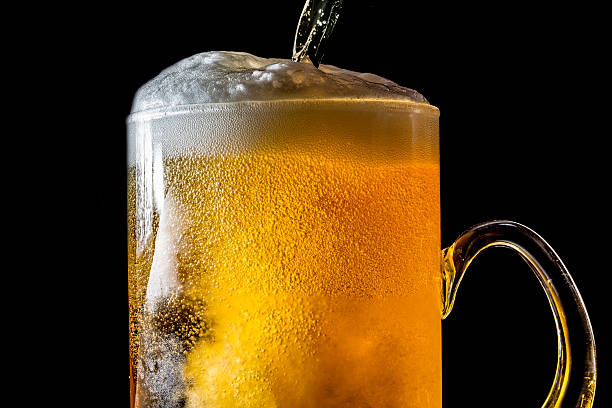 istock Beer overflowing large glass with foam and bubbles isolated 614150392