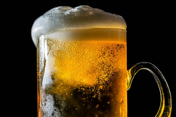 istock Beer overflowing large glass with foam and bubbles isolated 614150494