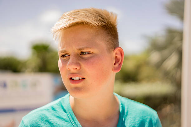 istock Young blond teenage boy looking to the side 614150566