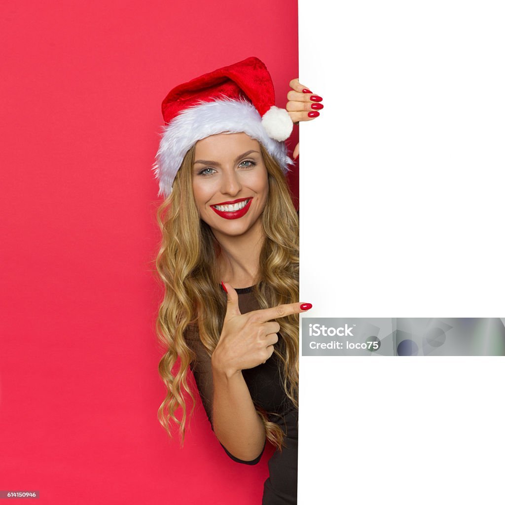 Mujer sonriente de Navidad señalando pancarta - Foto de stock de Mujer bella libre de derechos