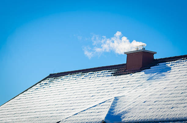 Smoking Winter Chimney White smoke comes out of a house's chimney on a winter day. eaves stock pictures, royalty-free photos & images