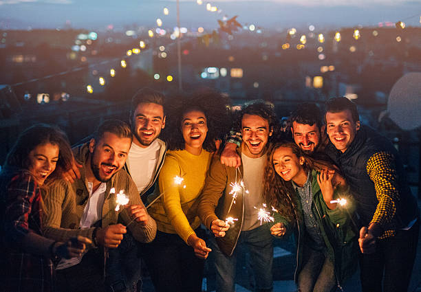 New year roof party Group of friends having a party on the roof. lighting fire cracker stock pictures, royalty-free photos & images