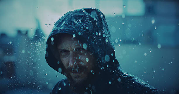 istock Man with raincoat under storm and heavy rain 614152630