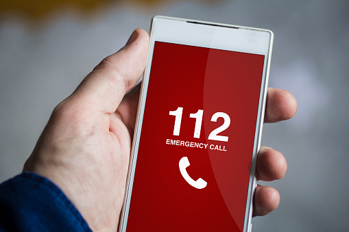 man hand holding emergency call smartphone. All screen graphics are made up.