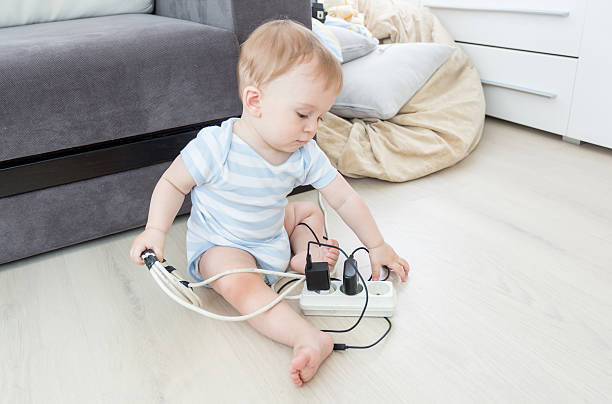 adorable bebé jugando con extensión eléctrica y cables - electric plug outlet pulling electricity fotografías e imágenes de stock