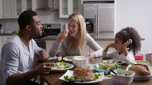 Girl and her mixed race parents dining in their kitchen, shot on R3D
