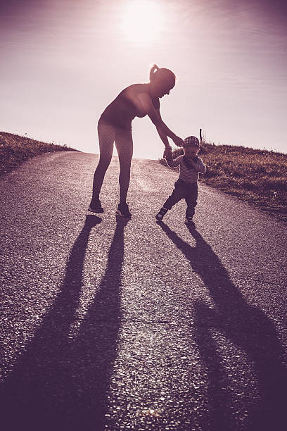 istock Baby walking with help of its parents - first steps 614205966