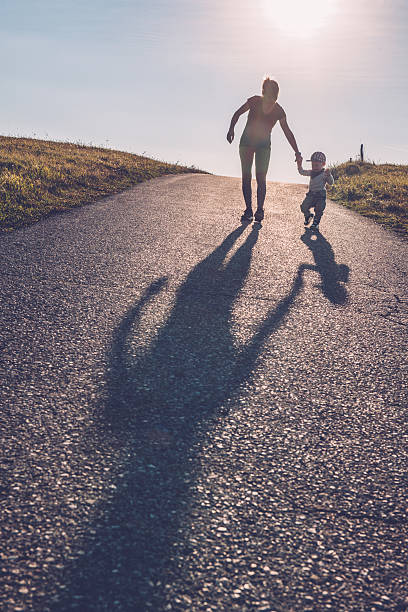 istock Baby walking with help of its parents - first steps 614206626