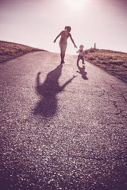 istock Baby walking with help of its parents - first steps 614208020
