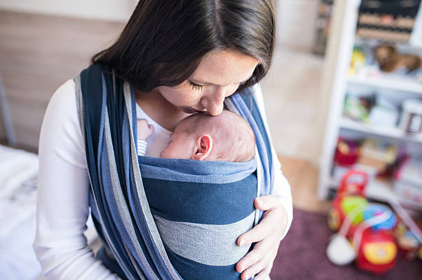 istock Beautiful young mother with her son in sling 614208592