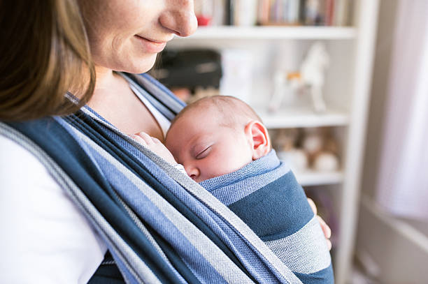 istock Unrecognizable young mother with her son in sling 614208662