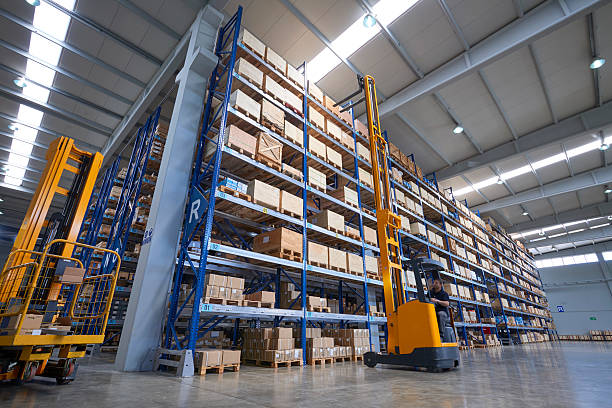 istock Forklift Lifting a cardboard box in warehouse aisle 614208706
