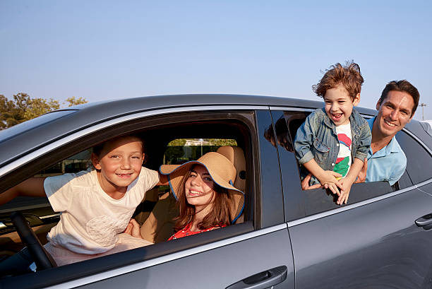 istock Happy family leaning out car windows 614208772