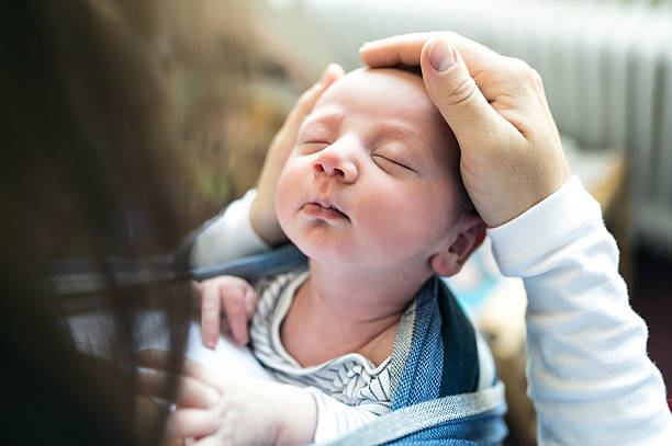 istock Unrecognizable young mother with her son in sling 614209232