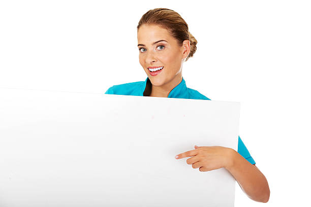 Young female doctor or nurse holding empty banner stock photo