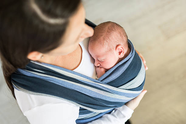 istock Unrecognizable young mother with her son in sling 614209800