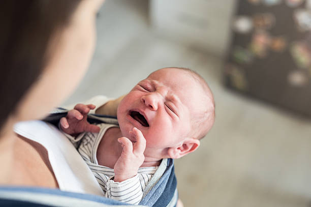 istock Unrecognizable young mother with her crying son in sling 614210404