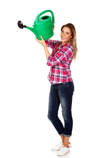istock Happy woman holding a watering can 614210802