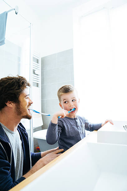 父と息子は歯を磨く - child brushing human teeth brushing teeth ストックフォトと画像